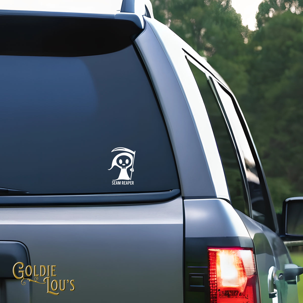 Seam Reaper Car Vinyl Decal on the rear window of a silver car